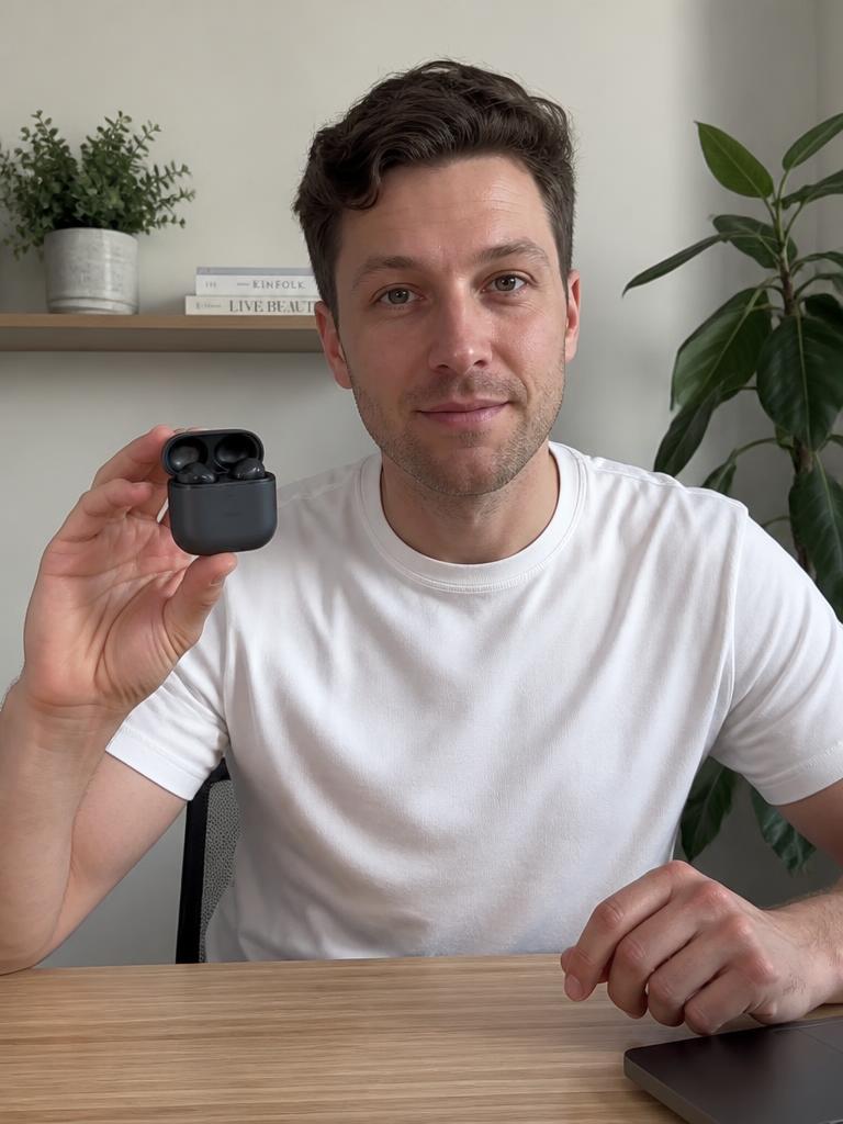 AI Twin example: Holding an unbranded earbud case at a clean desk.