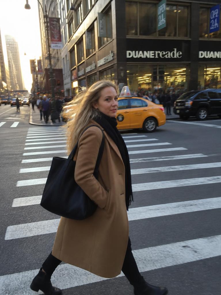 AI Twin example: Camel coat mid-crossing with taxis and storefronts behind.