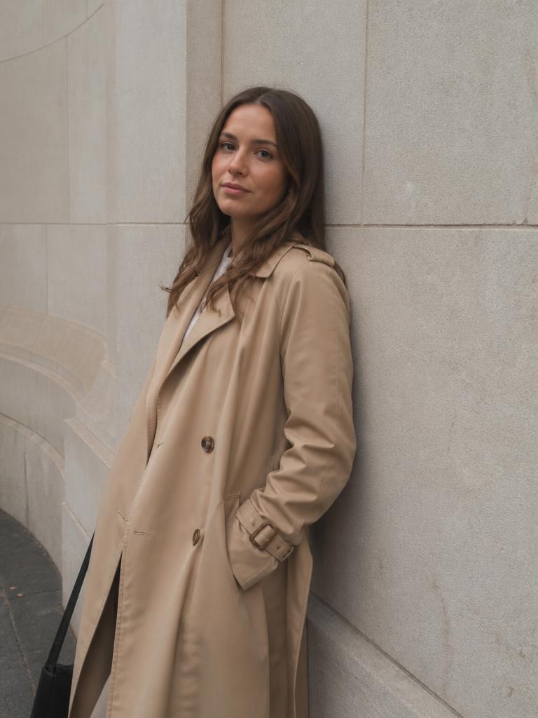 AI Twin example: Trench coat against pale stone — the easy relaxed pose.